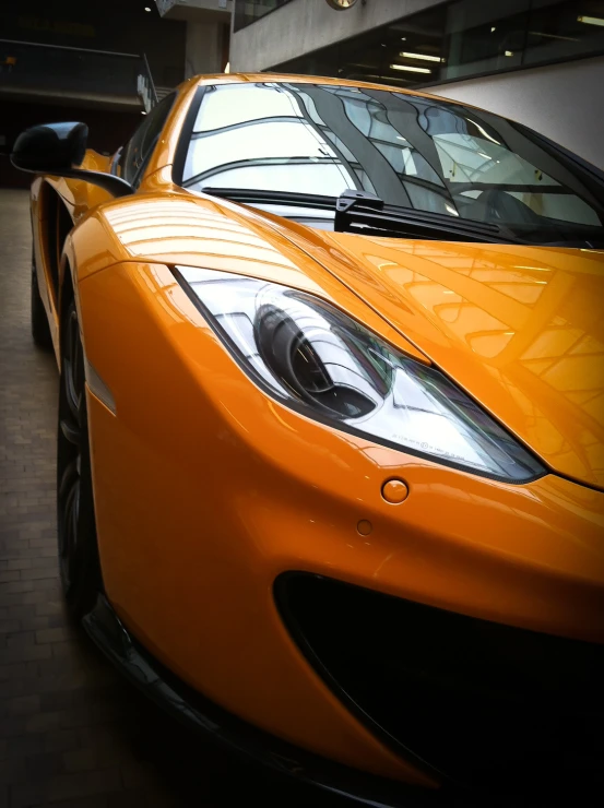 orange sports car parked in a parking garage