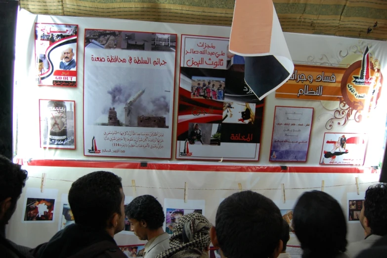 a group of people stand together around posters