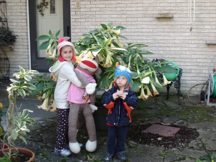 two young children wearing hats are outside