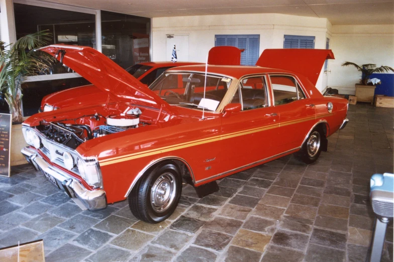 an old red car with a red hood