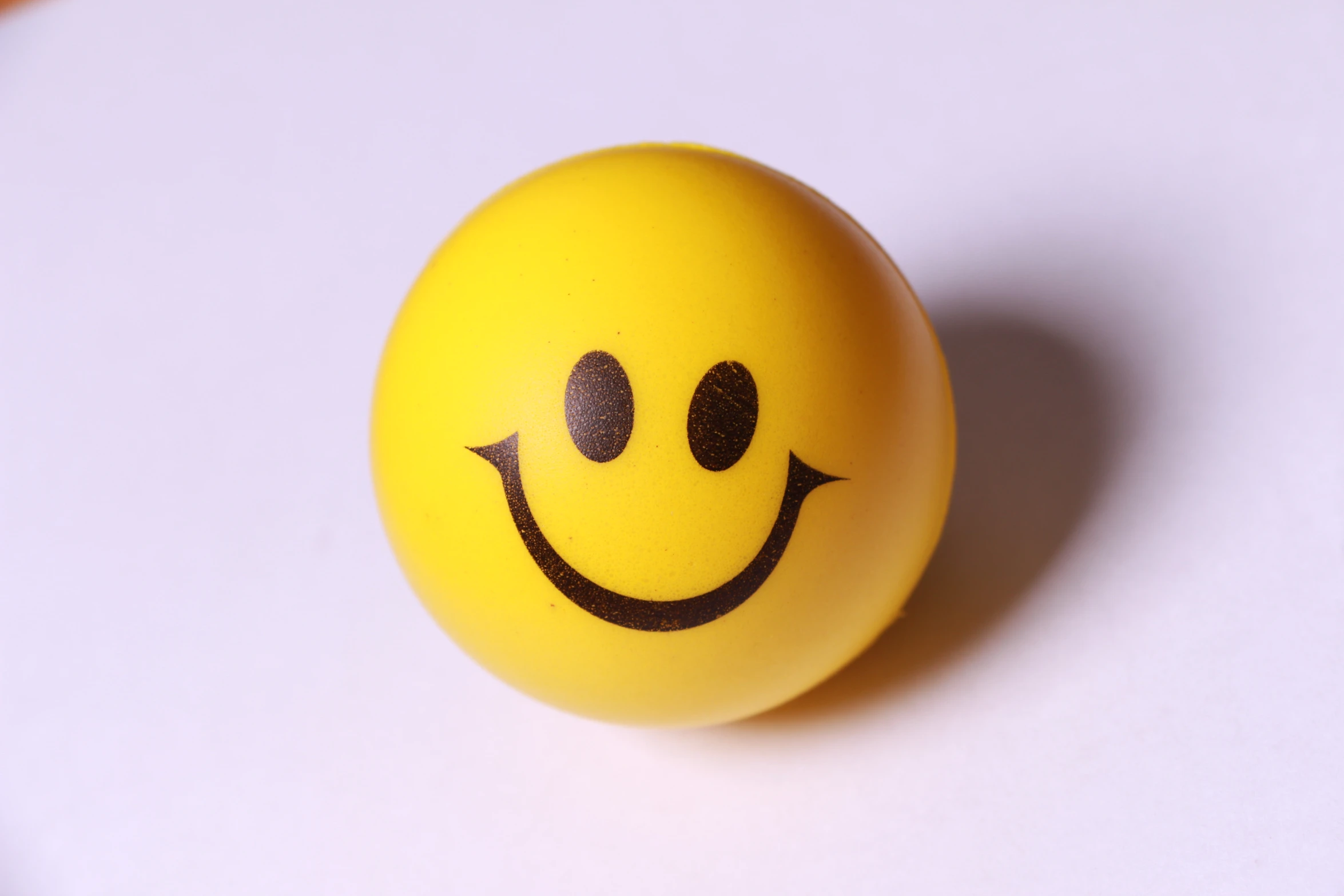 a yellow smile ball sitting on top of a table