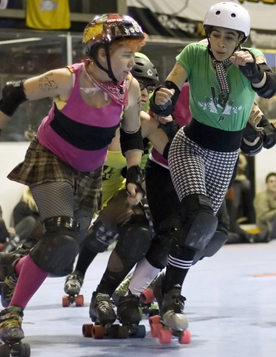 two people are skateboarding on a court, one woman is wearing rollerblade and one is wearing a helmet