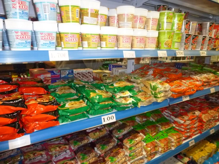 this grocery aisle has several racks of colorful food