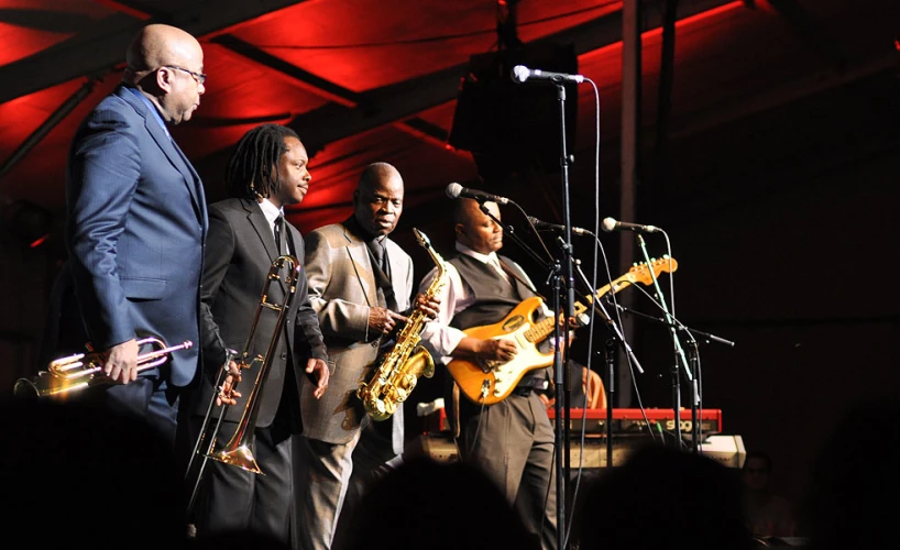 three men in suits with musical instruments standing together