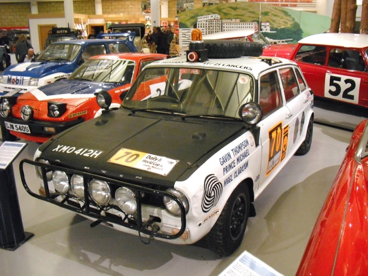 a row of cars in an exhibit with people walking