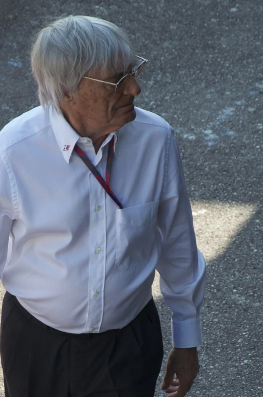 man with glasses and white shirt is walking in the street