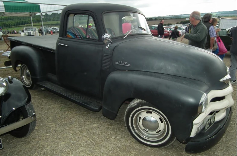 an old pickup truck parked near another car