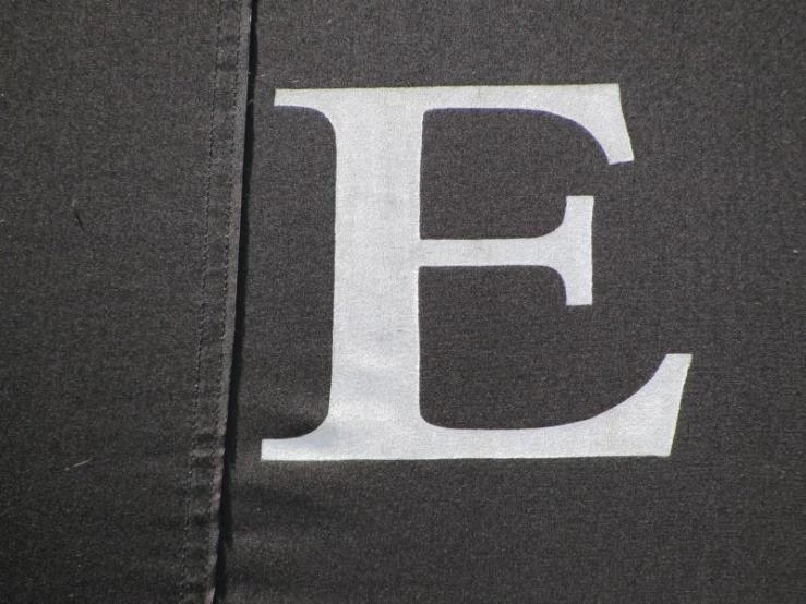 the front of a jacket with a black letter painted on it