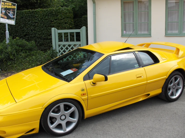 a bright yellow sports car is parked in front of a house