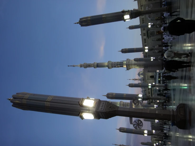 a po of some people walking around in front of a tower