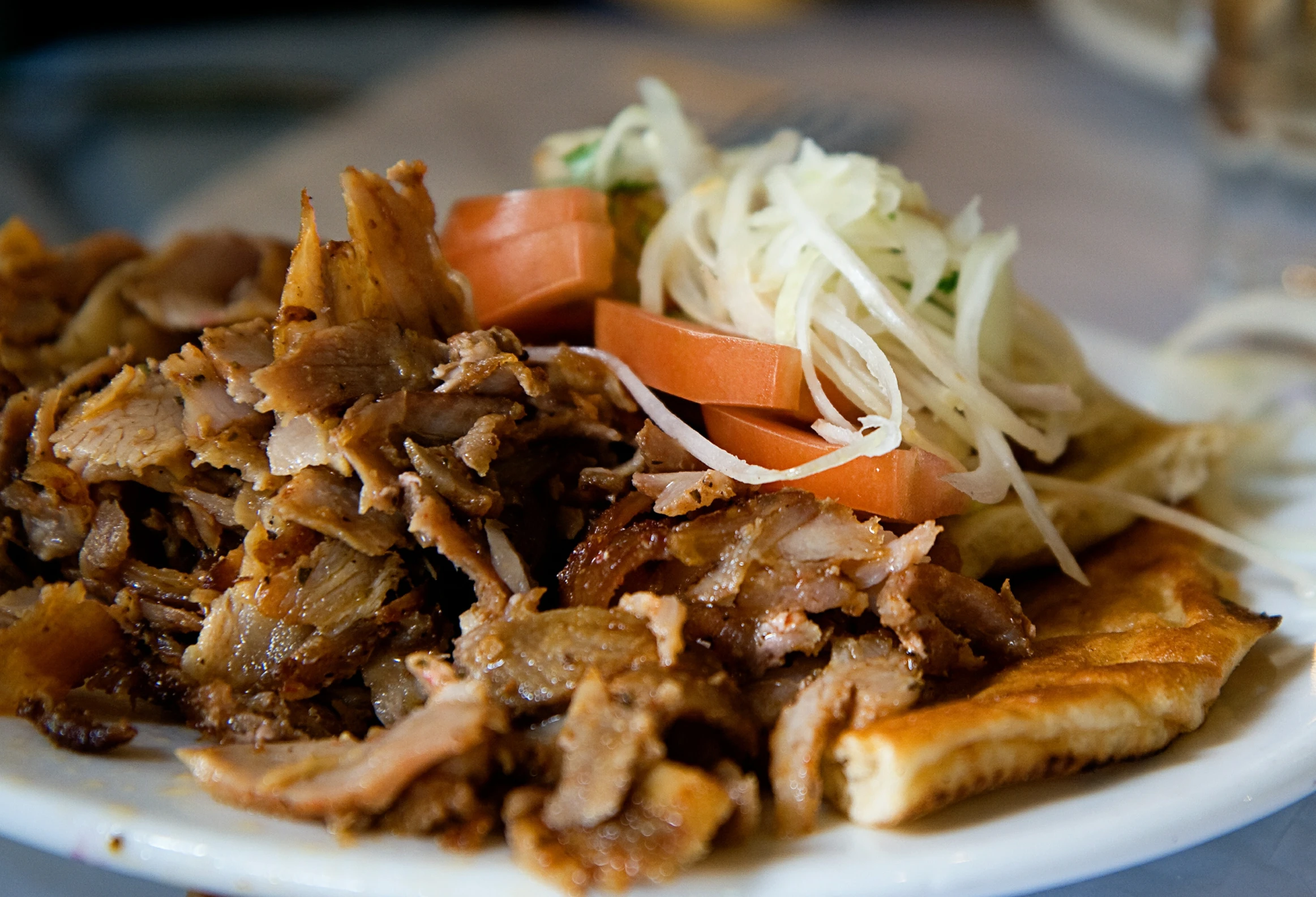 an plate of meat with coleslaw, carrots and onions