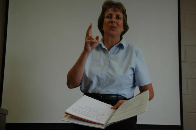 a woman giving the vulcan sign in front of her class room