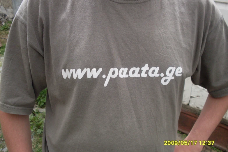 a close up of a person wearing a gray shirt with the word, www pata ge