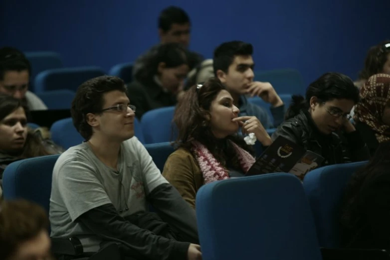 people sitting in rows waiting at a convention