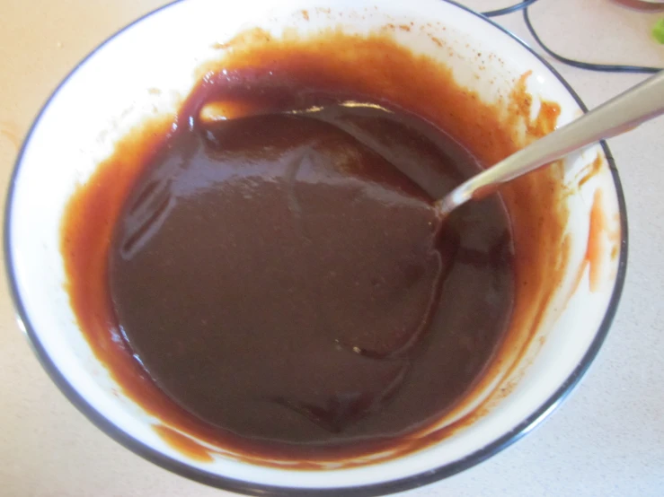 a spoon sitting in a bowl of brown sauce