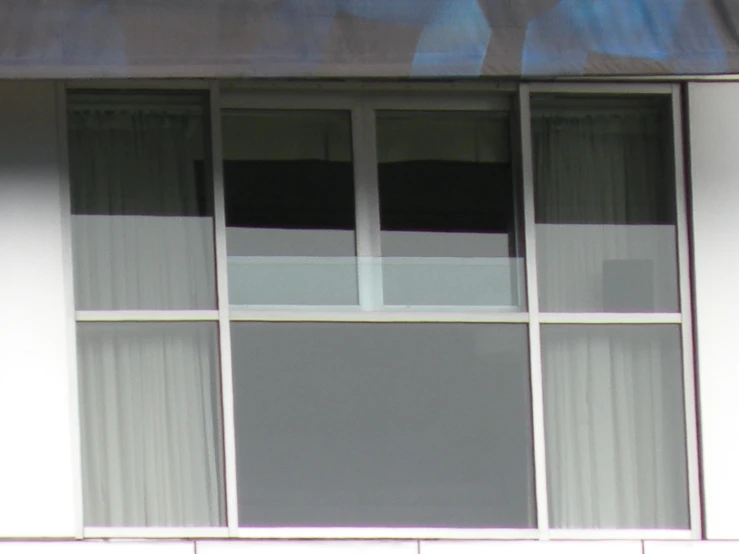 the white window with curtains is next to the building