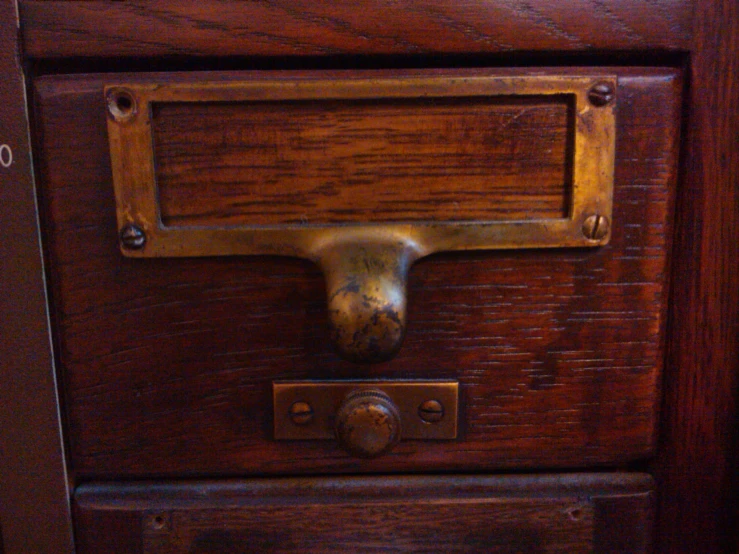 a drawer with an iron handle that is made of wood