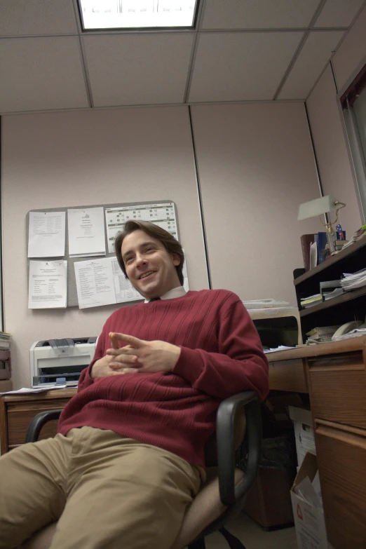 a man in his home office holding a cigarette