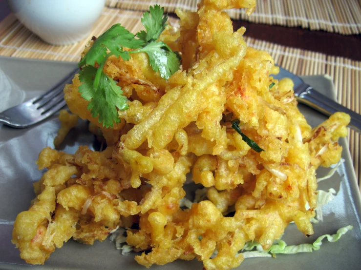 some fried vegetables are on a black plate