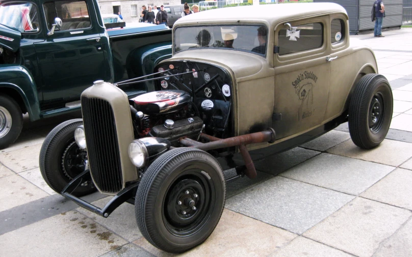 an old - timey, dusty truck sits parked in a line of old trucks