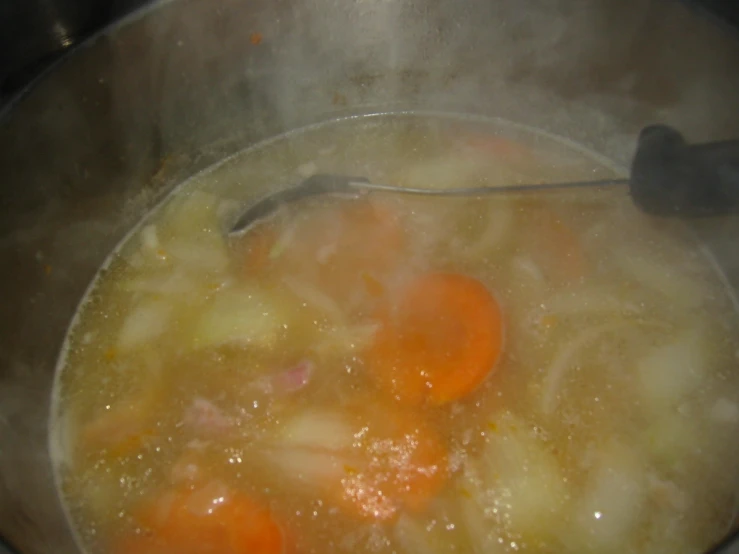 carrots are being cooked in a soup in an oven