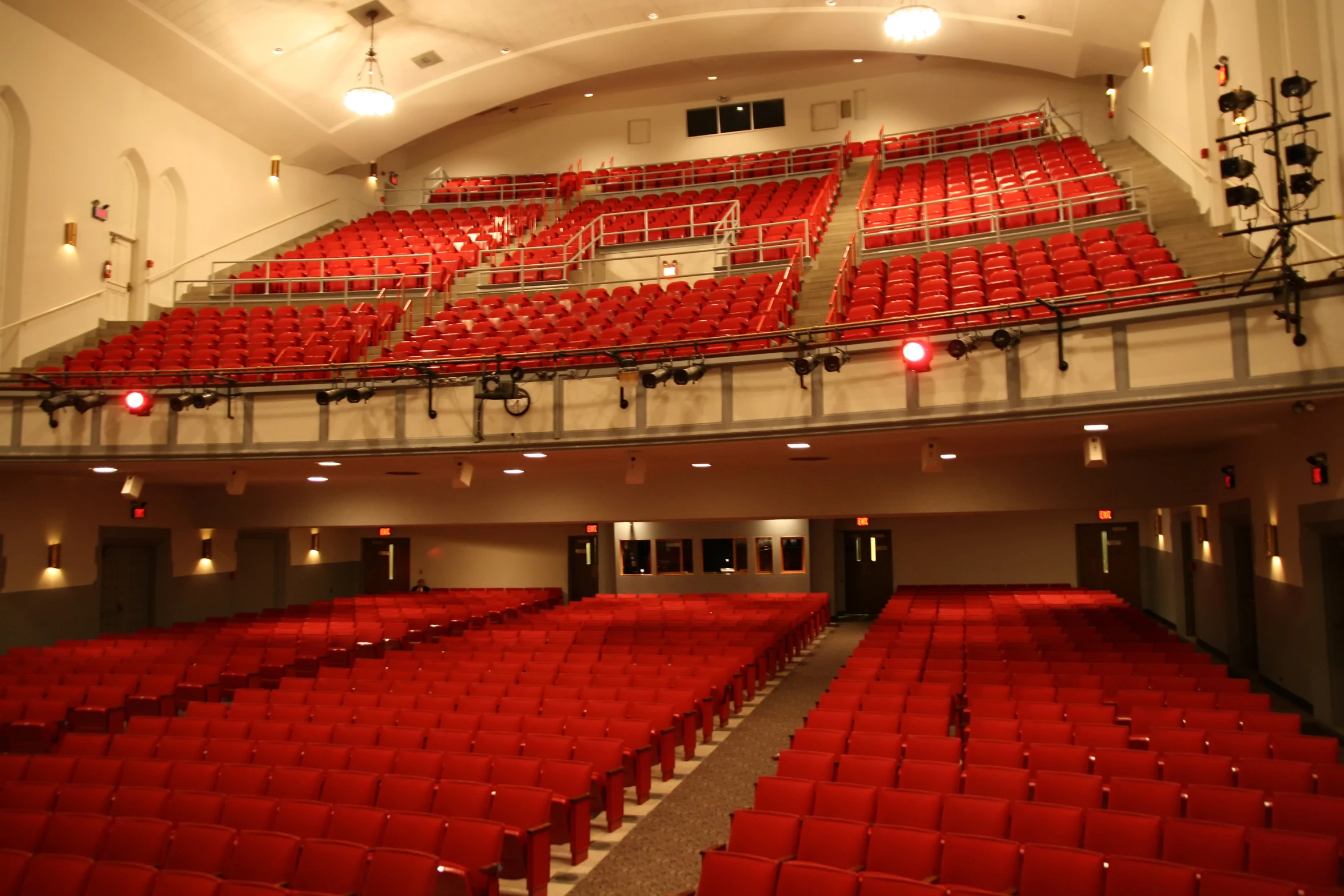 the auditorium is empty, with red chairs