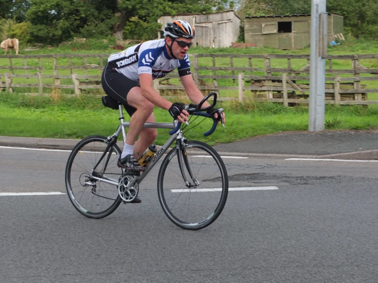 a male cyclist is riding down the road