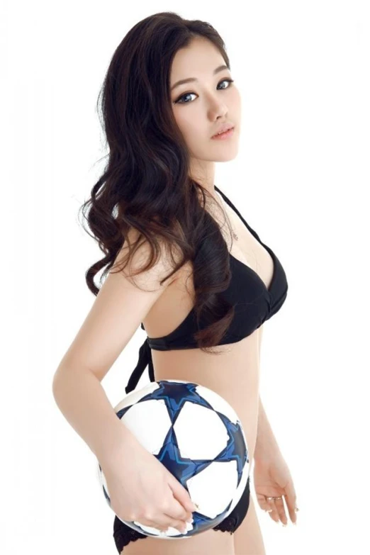 a woman wearing a bikini holding a soccer ball