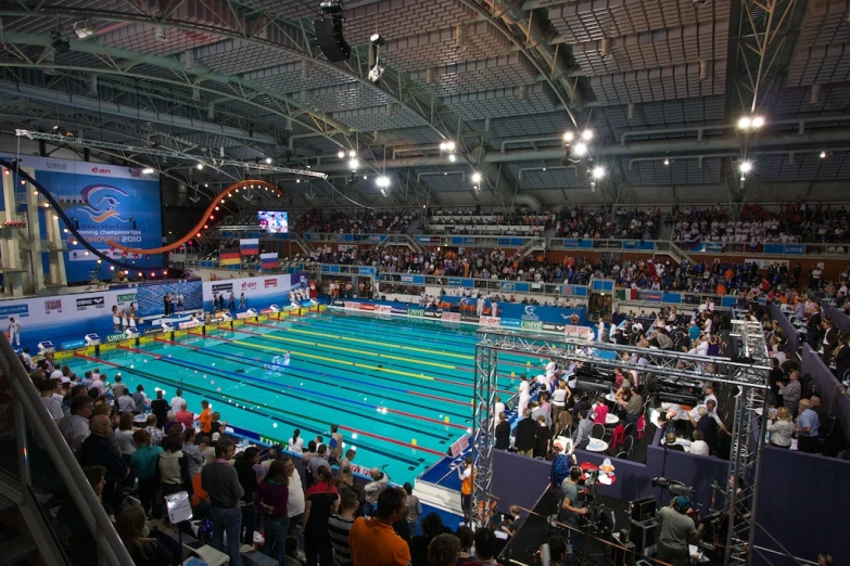 a large crowd looks on as a person swims