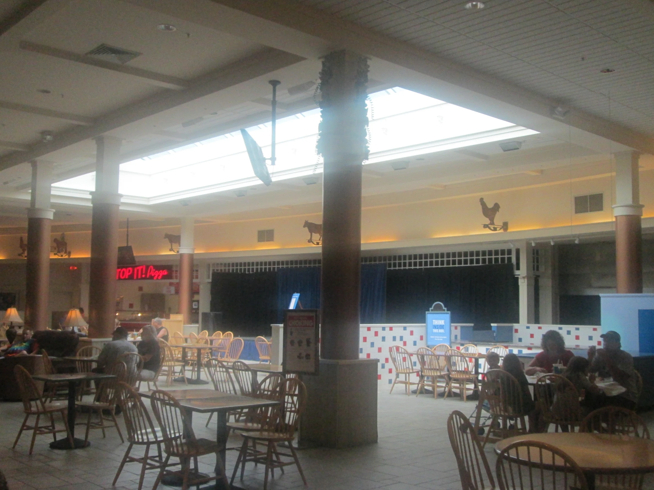 a room filled with people sitting at tables and a big screen