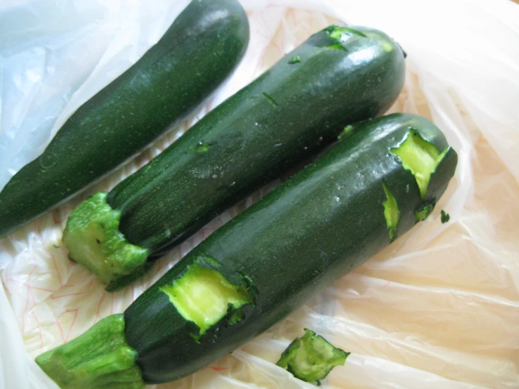 two zucchini cut in half sitting on a piece of plastic