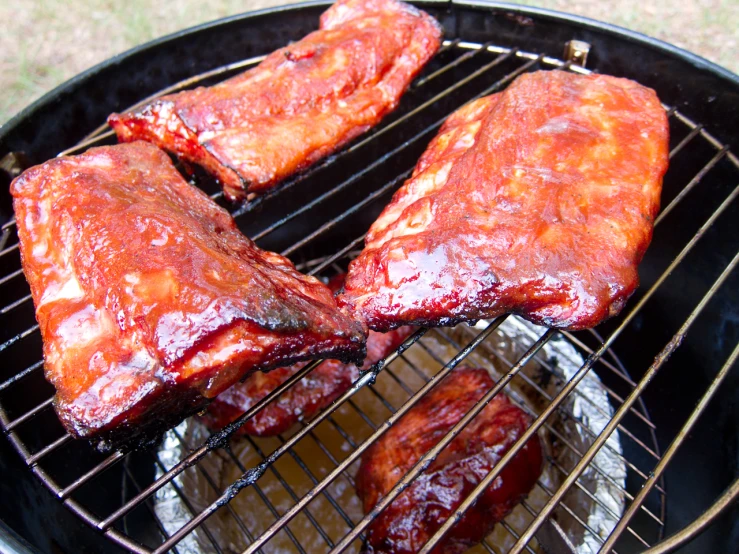 bbq ribs being cooked on a large grill