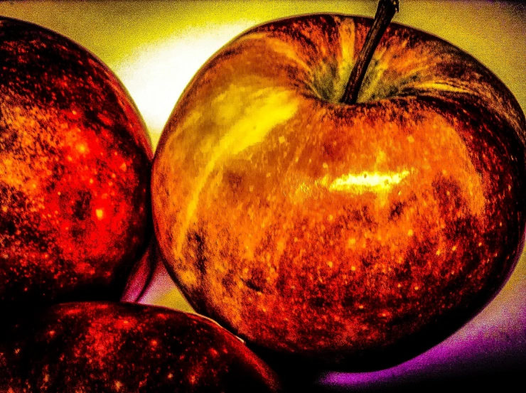 some yellow and red apples are sitting in a pile