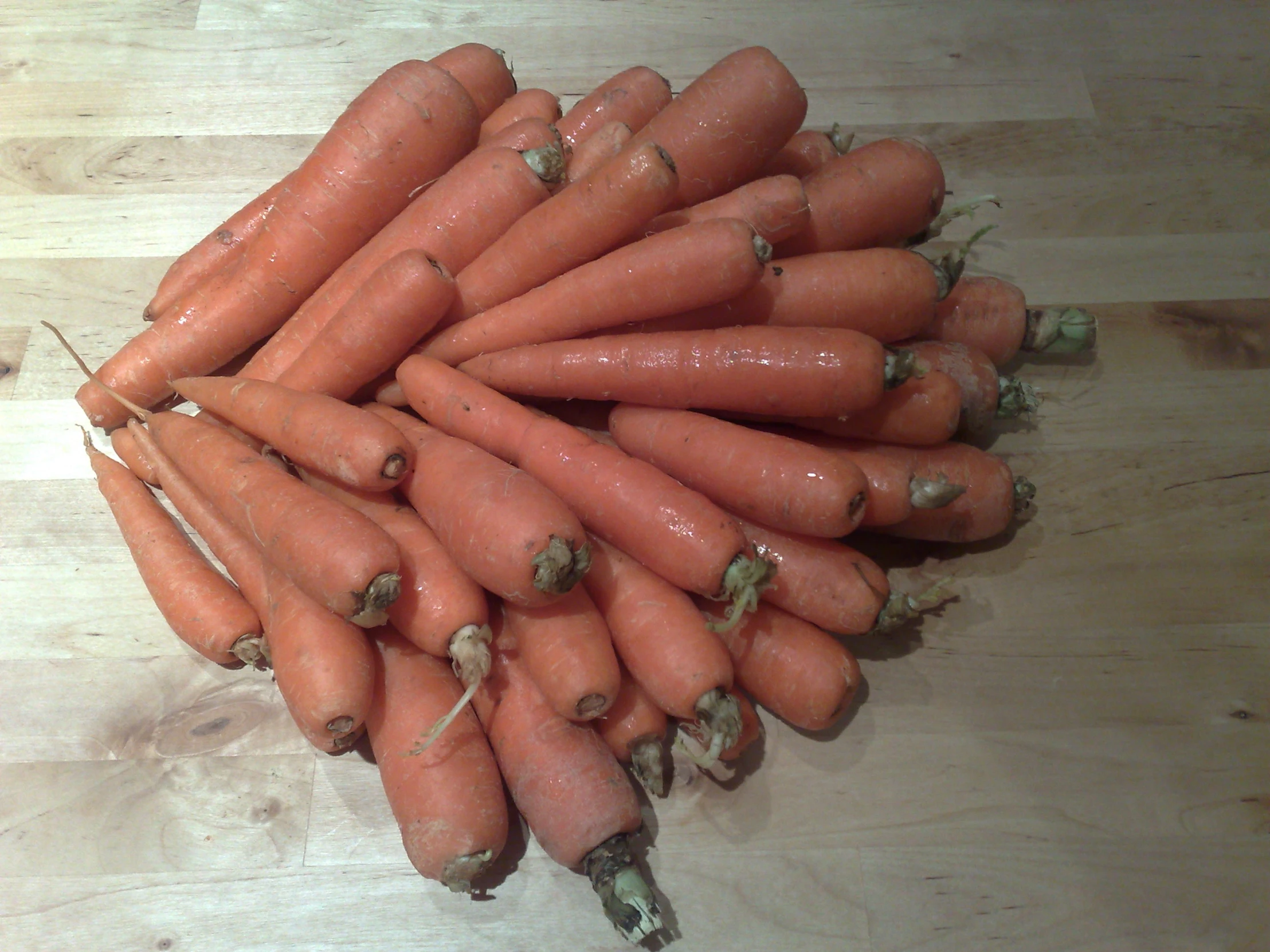 a pile of carrots sitting on top of a wooden table