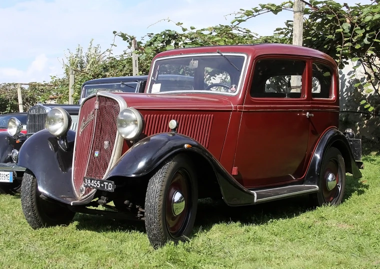 an antique car is parked in a field