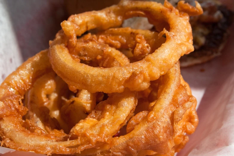 fried onion rings sitting in a red basket