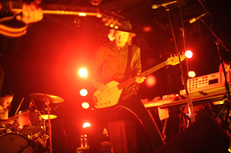 man playing on bass guitar and drums in the night