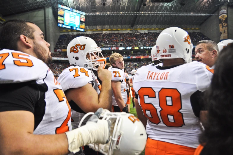 the group of football players is talking to each other