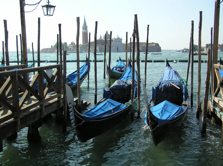 several small blue boats in water near a pier