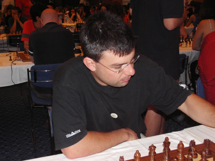 a man sitting in front of a chess set