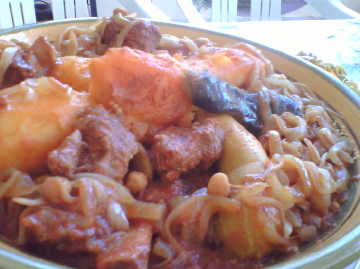 a bowl full of some pasta and meat with tomatoes