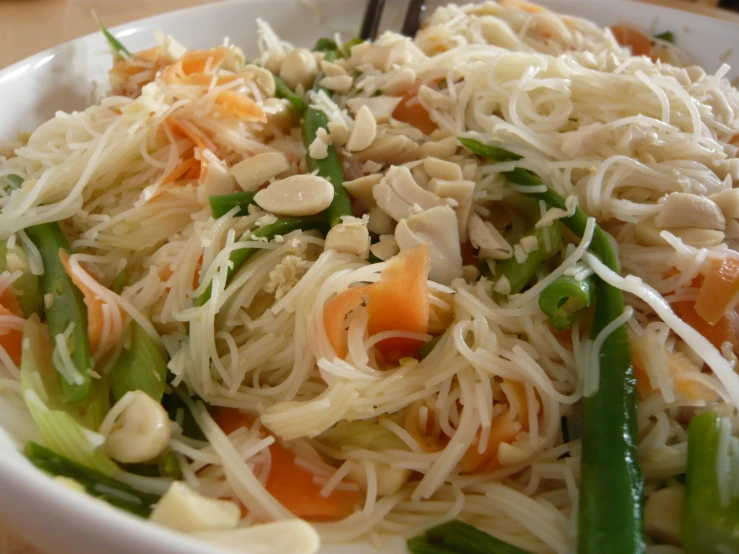 white plate with vegetables and noodles that are on top