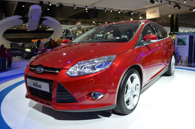 a red car sits on display at the auto show