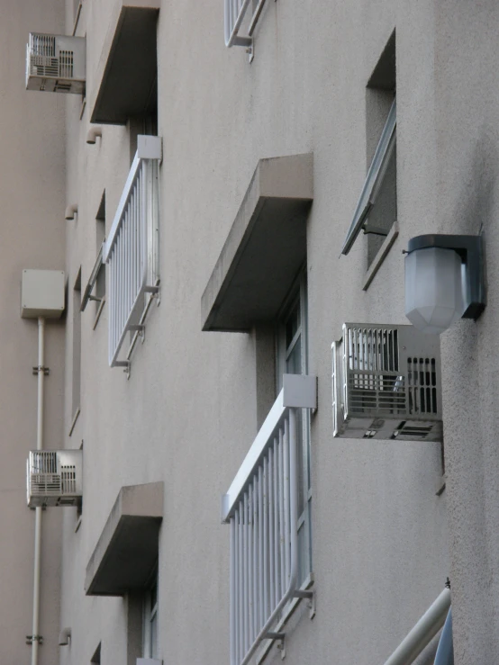 a tall gray building with some balconies on the windows