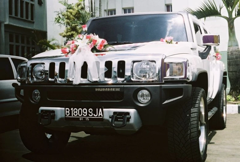 a hummer that is decorated with flowers and ribbons