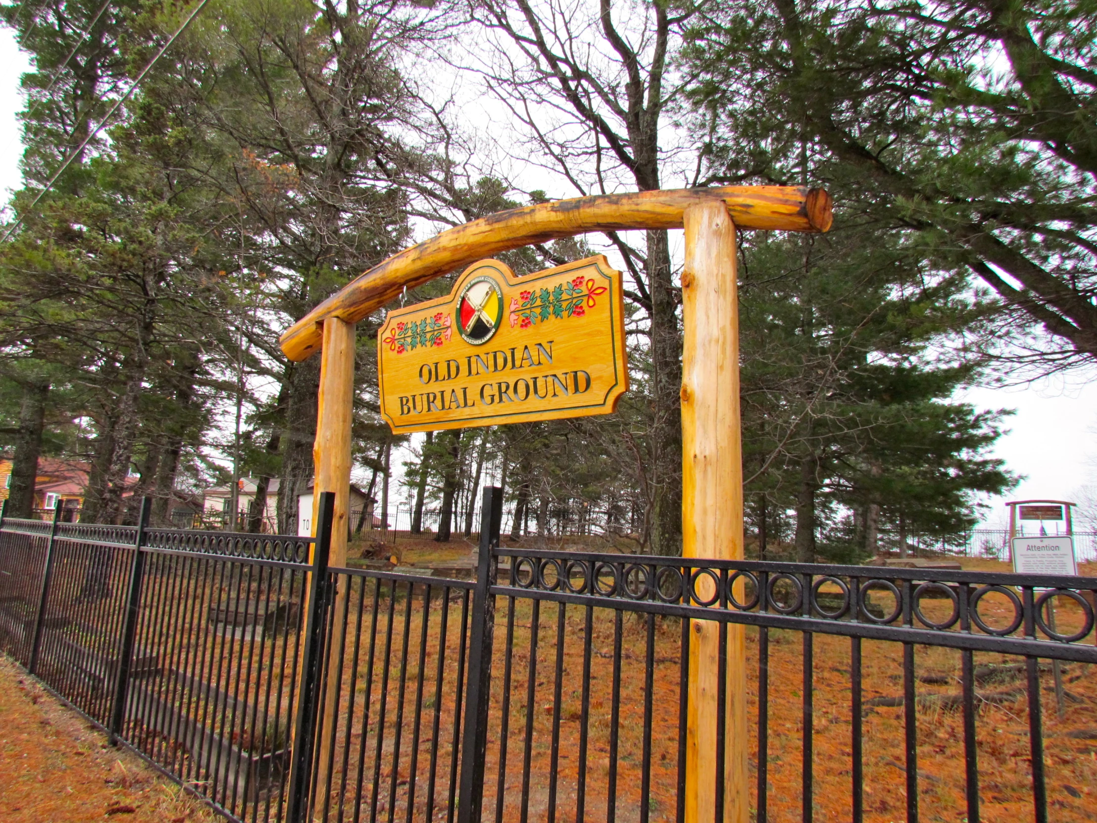 a very long wooden sign mounted on a metal fence