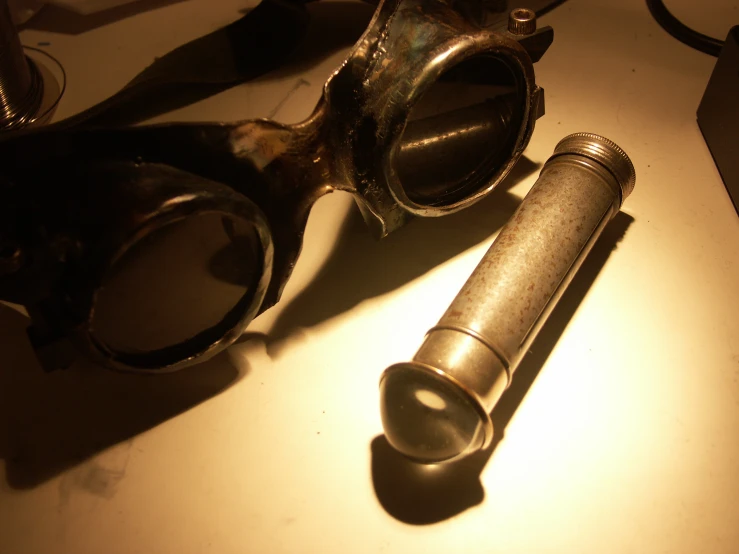 a close up of a gun and glasses on a table