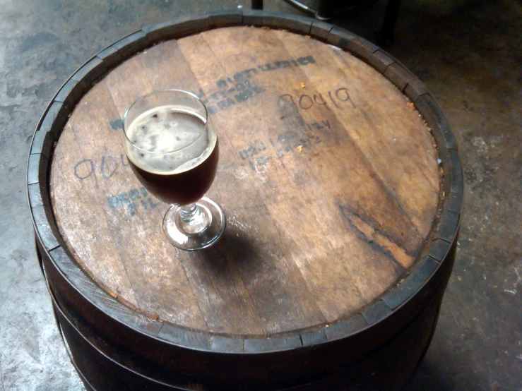 a glass on top of a wooden barrel