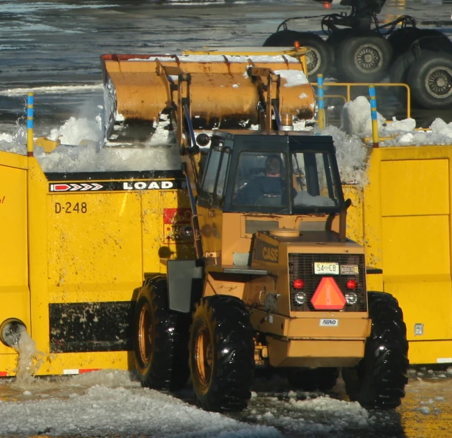 two large utility vehicles are parked on the beach