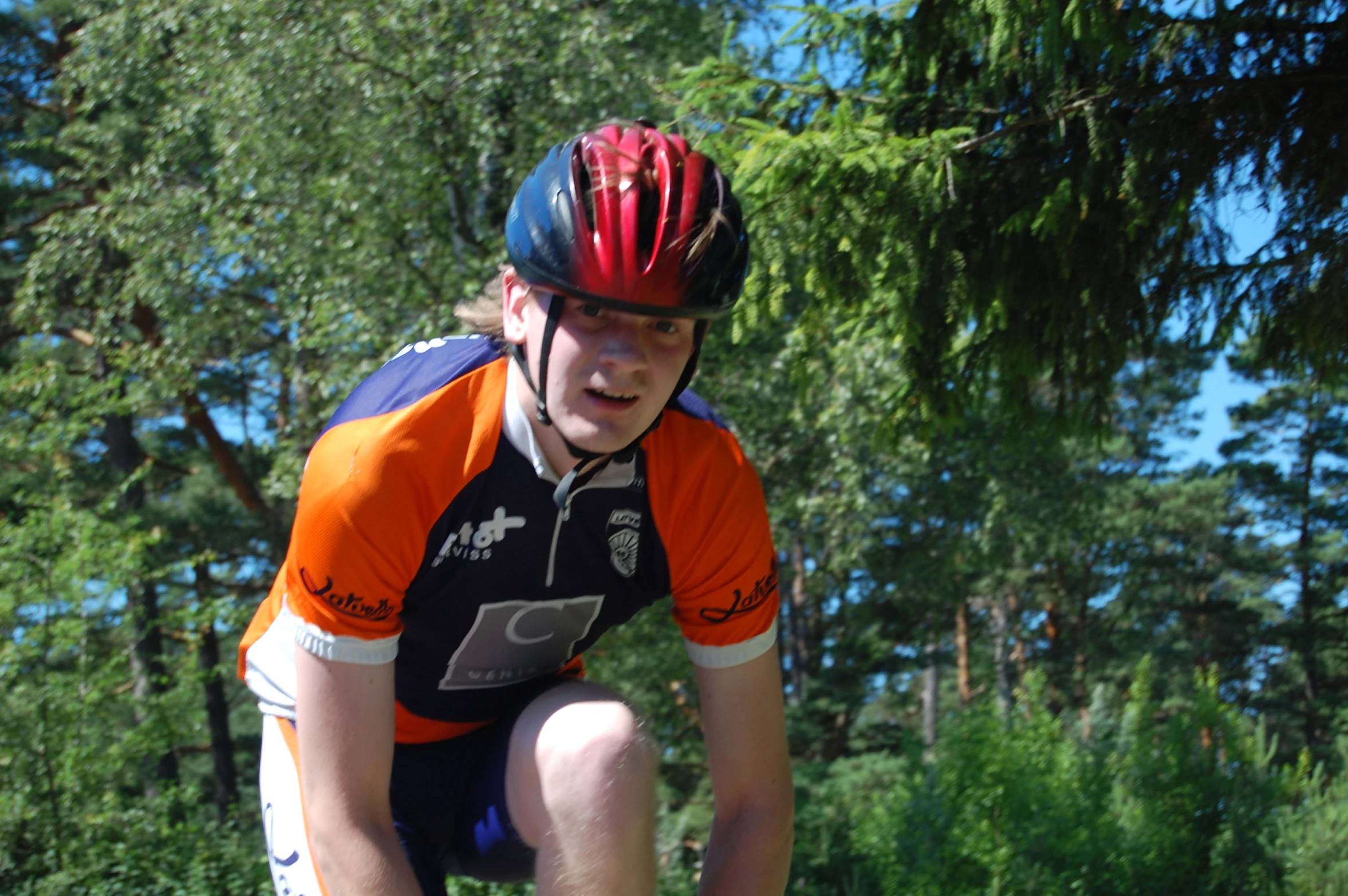 a man riding on the back of a bicycle wearing a helmet